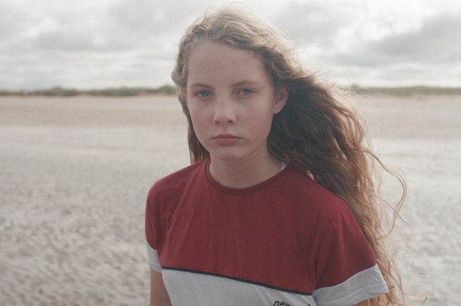 Child standing on beach as part of the Any of Us film