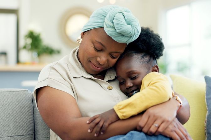 Black carer nursing a child