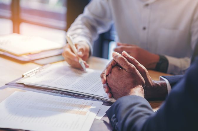 Two adults sat at a table with paperwork