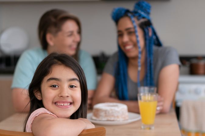 Two females and a child at a table smiling